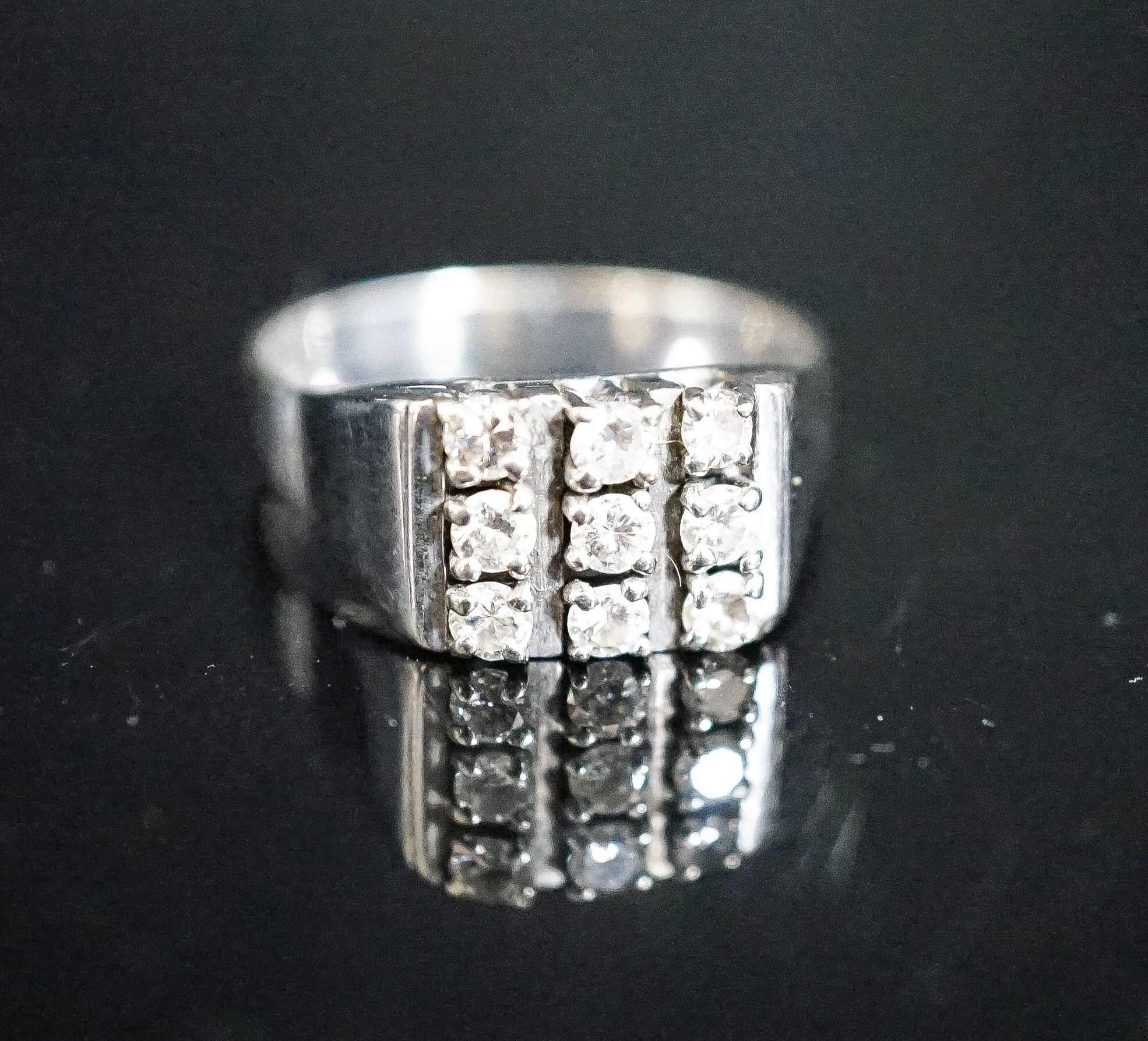 A 750 white metal and nine stone diamond set tablet ring, size S/T, gross 7.6 grams.